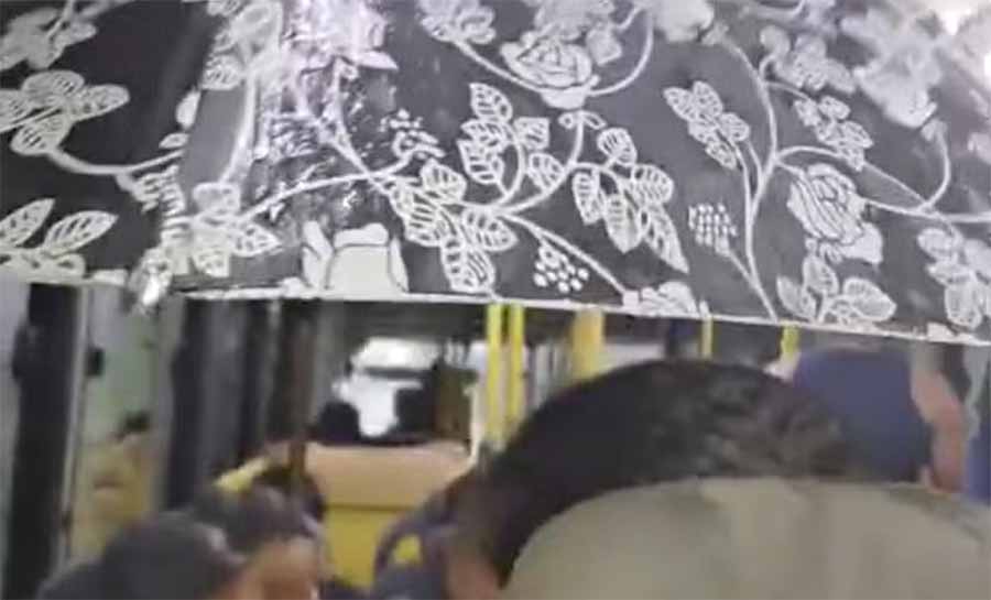 Com goteira em teto de ônibus, passageira usa guarda-chuva para se proteger em Rio Branco