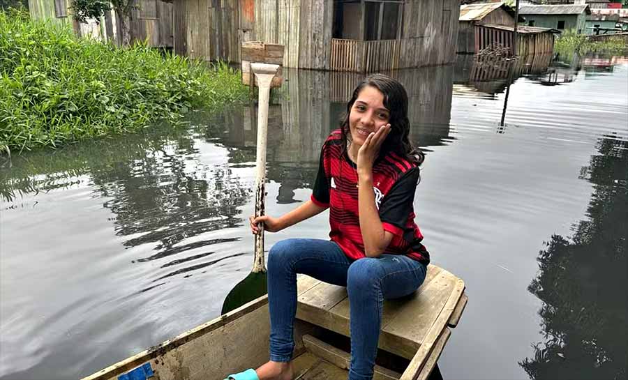 De canoa, adolescente de 17 anos ajuda no transporte de vizinhos em bairro alagado em Rio Branco